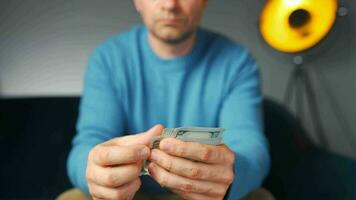 Man counting US Dollar bills or paying in cash. Concept of investment video