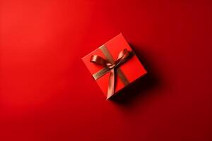 Red gift box with red ribbon on red background with copy space. photo