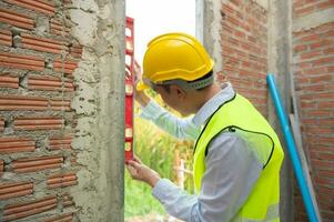 An Asian Engineering man wearing safety helmet checking construction site analyzing about project progress photo