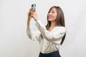 Young asian woman using smartphone over white background, technology concept. photo