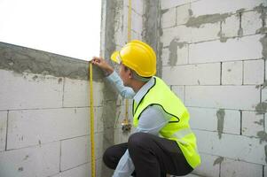 An Asian Engineering man wearing safety helmet checking construction site analyzing about project progress photo