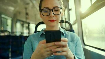 femme dans tram en utilisant téléphone intelligent bavardage et envoyer des SMS avec amis. ville, urbain, transport. lent mouvement video