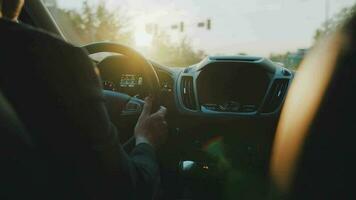 Man drives a car along the road, the setting sun shines in the windshield video