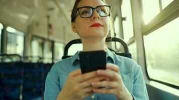 femme dans tram en utilisant téléphone intelligent bavardage et envoyer des SMS avec amis. ville, urbain, transport. lent mouvement video