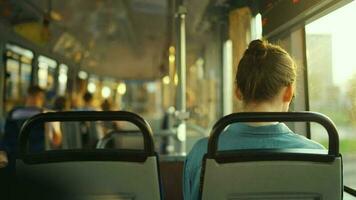 Woman in tram using smartphone chatting and texting with friends, back view video