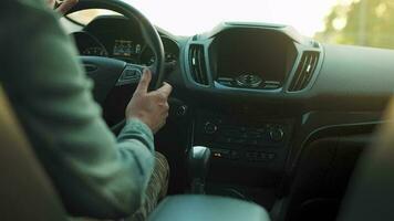 Mens schijven een auto langs de weg, de instelling zon schijnt in de voorruit video