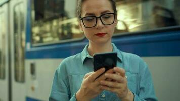 mujer en tranvía utilizando teléfono inteligente chateando y mensajes de texto con amigos. ciudad, urbano, transporte. lento movimiento video