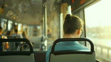 Woman in tram using smartphone chatting and texting with friends, back view video