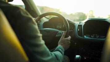 Man drives a car along the road, the setting sun shines in the windshield video