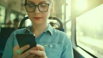 mulher dentro eléctrico usando Smartphone conversando e mensagens de texto com amigos. cidade, urbano, transporte. lento movimento video