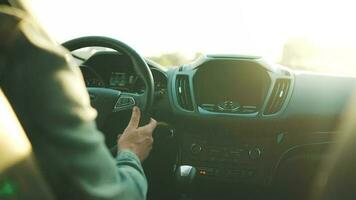 Man drives a car along the road, the setting sun shines in the windshield video