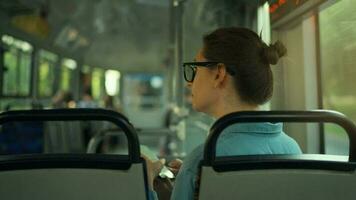 femme dans tram en utilisant téléphone intelligent bavardage et envoyer des SMS avec amis, retour vue video