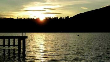 silueta ver de lago montaña puesta de sol video