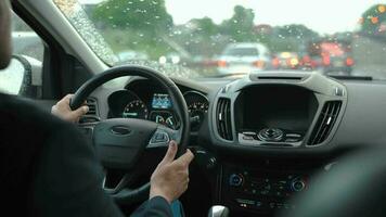 Mens schijven een auto langs de weg in de stad gedurende de regen video