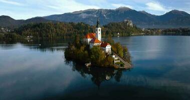 aereo Visualizza di lago sanguinato e il isola nel il mezzo di esso, slovenia. pellegrinaggio Chiesa di il assunzione di Maria nel lago sanguinato video