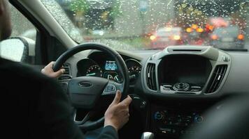 homme disques une voiture le long de le route dans le ville pendant le pluie video