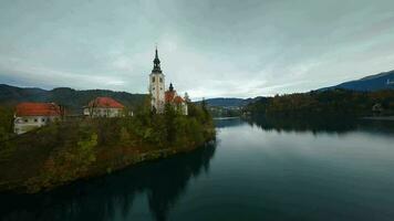 aéreo ver de lago desangrado y el isla en el medio de él, Eslovenia. peregrinaje Iglesia de el suposición de María en lago desangrado video