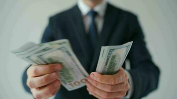 Formally dressed man counting US Dollar bills, close-up video