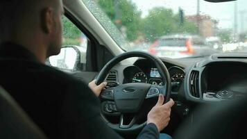 homme disques une voiture le long de le route dans le ville pendant le pluie video