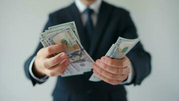 Formally dressed man counting US Dollar bills, close-up video