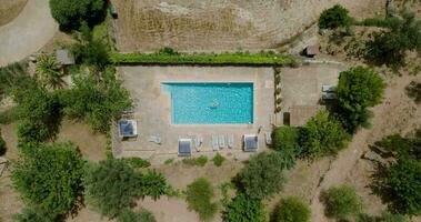 View from the top as a woman in red swimsuit swims in the pool video