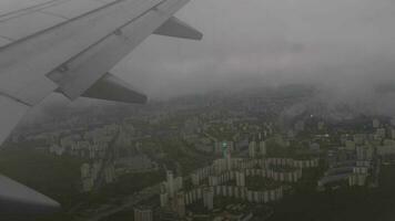 hublot, vue de le ville de au-dessus de. approchant atterrissage, en volant par le des nuages video