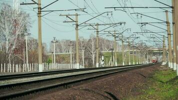 il elettrico treno cavalcate su il rotaie. treno, elettrico treno guida su un' Ferrovia traccia nel il campagna. video