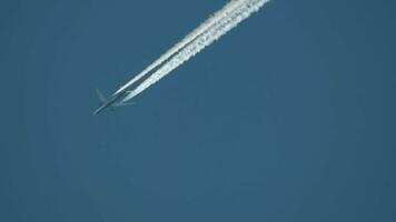 Aircraft contrail against clear blue sky. Airplane flying high video