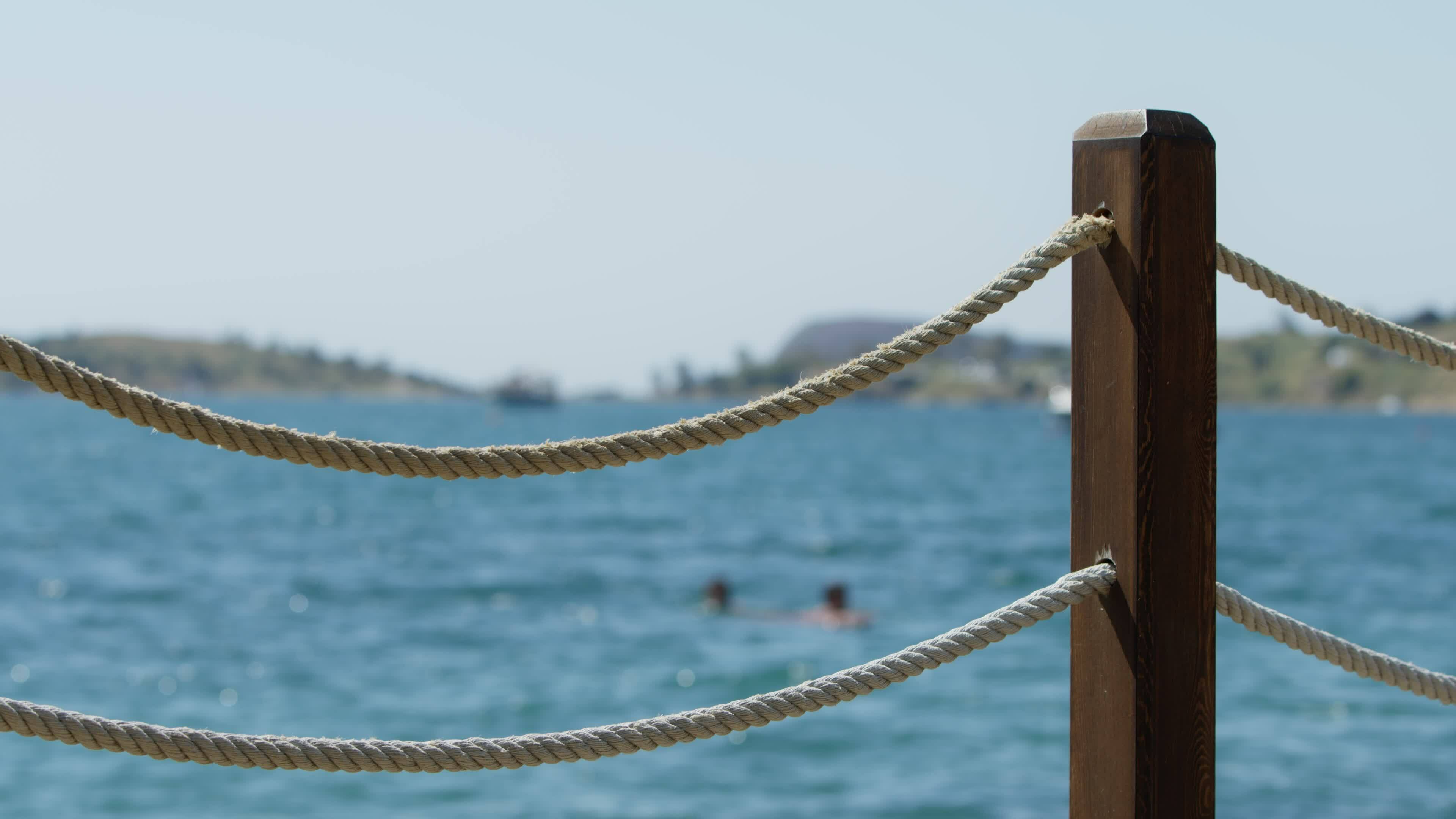 https://static.vecteezy.com/system/resources/thumbnails/024/852/010/original/fence-made-of-rope-and-wood-near-the-sea-free-video.jpg