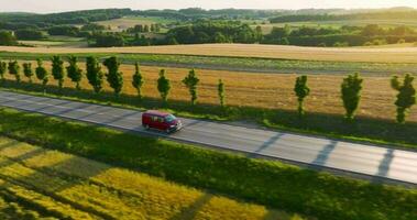 Aerial view of the road and car driving along it at sunset video