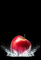 red apple on water splash on black background photo