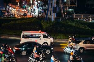 Ho Chi Minh City, Vietnam - Apr 14, 2023 Traffic jam at Dien Bien Phu roundabout with its four-faced clock tower a symbol of Ho Chi Minh city. Light trail from cars. photo