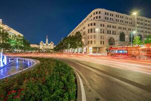 Ho Chi Minh, Viet Nam - 10 April 2023 Saigon City Hall, Vincom Center towers, colorful street traffic and tropical plants against the amazing night. Saigon downtown with its famous landmarks. photo