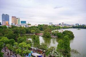 Hanoi, Viet Nam - 13 May 2023 Aerial view of Hoan Kiem Lake  Ho Guom or Sword lake in the center of Hanoi in the fog in the morning. Hoan Kiem Lake is a famous tourist place in Hanoi. Travel concept photo