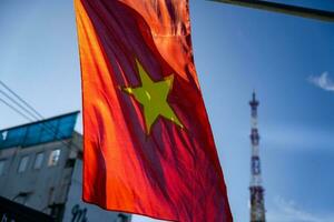 Vietnamese flag waving in the wind on a pole against a blue sky background photo