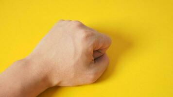 fist hand is isolated on yellow background. photo