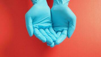 Empty two hand with gloves doing sign for help on red background. photo