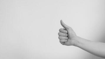 Hand is doing like or thumbs up sign on white background.Black and white picture. photo