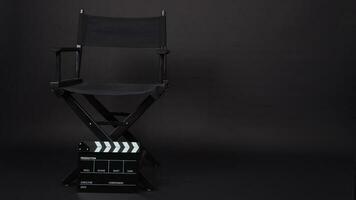 director chair and Clapperboard or movie slate use in video production ,film, cinema industry on black background. photo