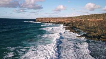 Flying from the shore over big waves, rocky coastline. video