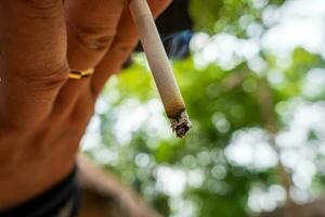 Close up male hand holding a cigarette. photo