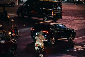 Ho Chi Minh City, Vietnam - Apr 14, 2023 Traffic jam at Dien Bien Phu roundabout with its four-faced clock tower a symbol of Ho Chi Minh city. Light trail from cars. photo