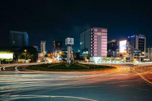 Ho Chi Minh City, Vietnam - Apr 14, 2023 Traffic jam at Dien Bien Phu roundabout with its four-faced clock tower a symbol of Ho Chi Minh city. Light trail from cars. photo