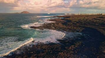 A beautiful overflight of the volcanic coast, a volcano in the distance. video