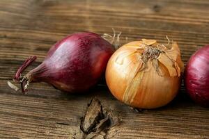 Yellow and red onions on a wooden board photo