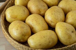 Raw potato in a wicker bowl photo