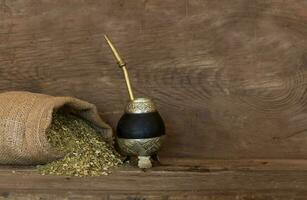 Mate and yerbamate on rustic wooden background. Traditional South American infusion photo