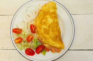 plate with omelette and salad of cherry tomatoes and lettuce photo
