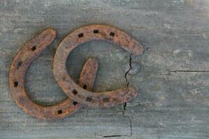 antiguo oxidado herraduras en rústico madera con sitio para texto foto
