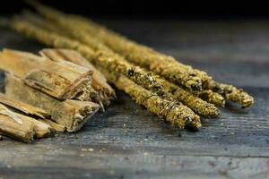 close-up of handmade incense and natural ingredients on wooden background photo